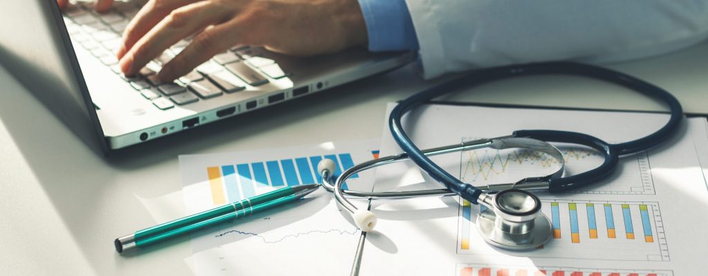 doctor working with medical statistics and financial reports in office